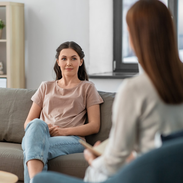 Female client sat on a sofa taking part in a therapy session with a Counsellor in our Lincoln office