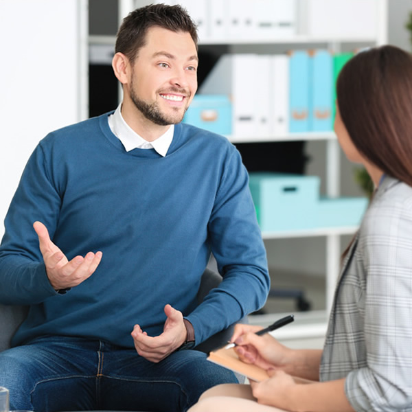 Man sat on a chair receiving counselling from a Therapist in our counselling space