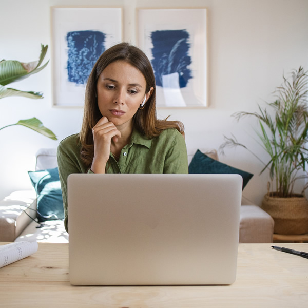 Counsellor sitting at a desk using a laptop to deliver online therapy to a UK client