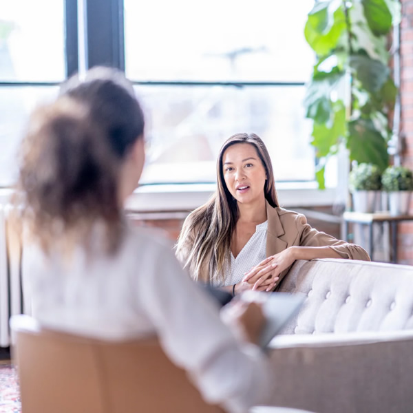 A client sat on a sofa in a therapy session with an Ivy Light Therapist