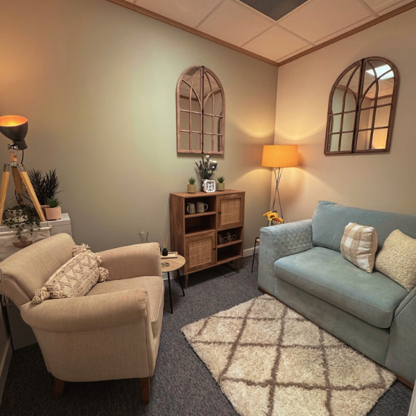 Therapy room in our Lincoln offices with sofa and one chair